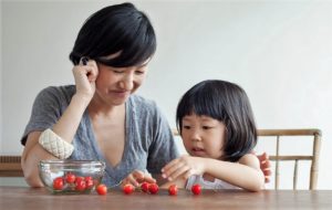 Mother and child practicing counting with cherries